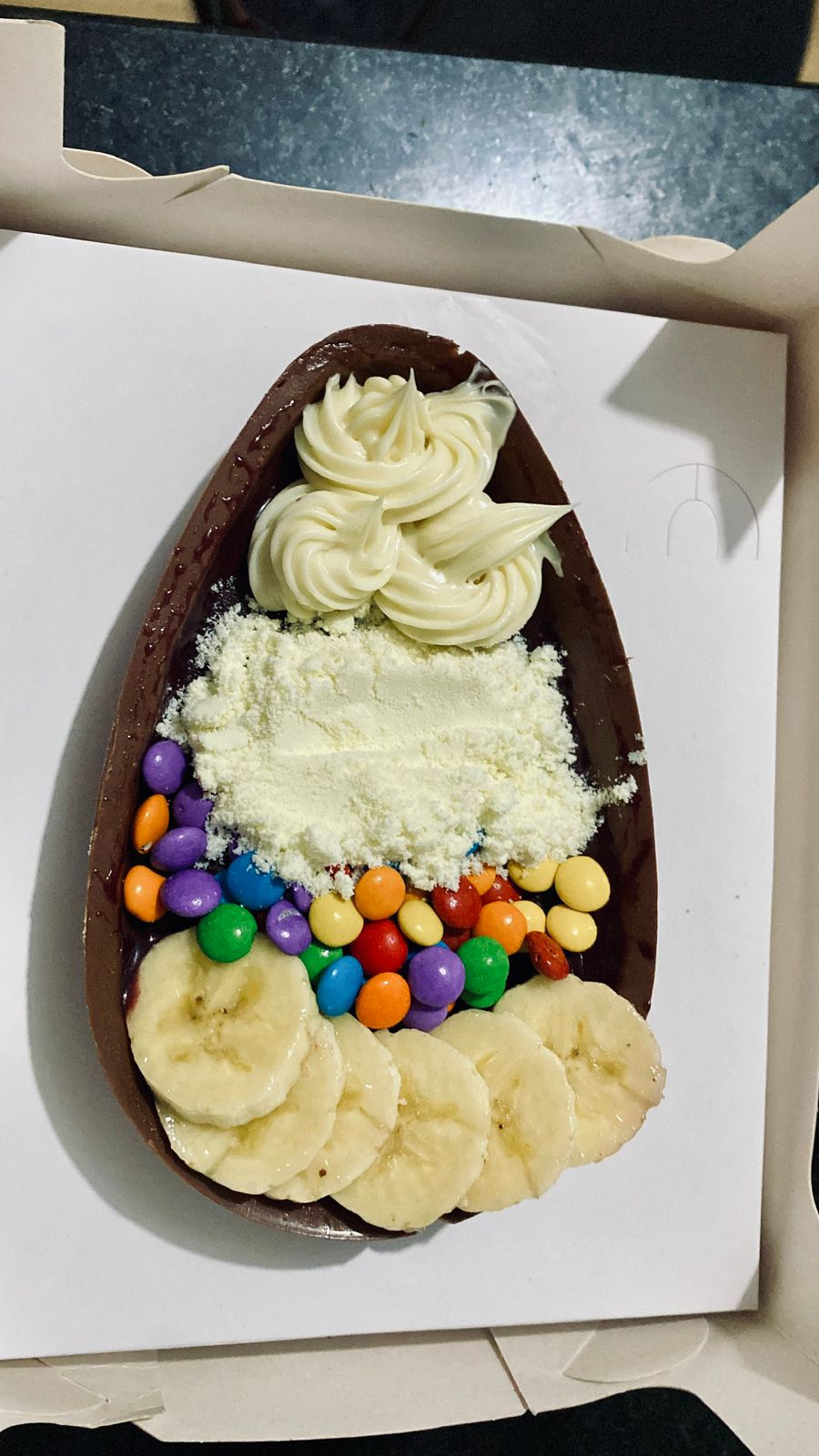Sobremesa de açaí com banana, creme e confeitos coloridos