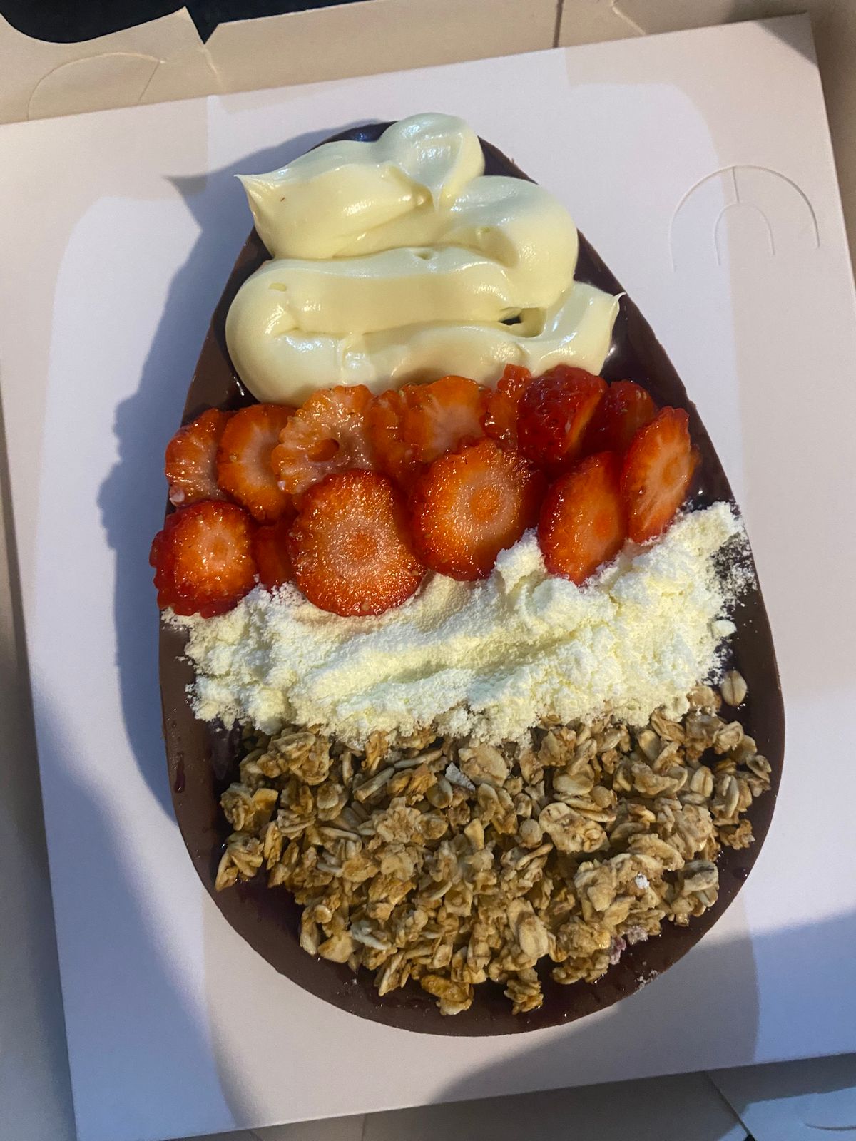 Sobremesa de açaí servida em casca de chocolate com morango